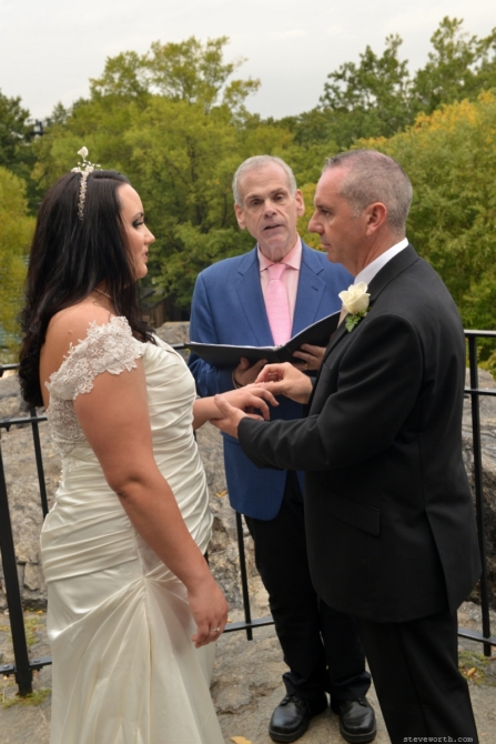 Groom Puts Ring on Bride by: Steve Worth